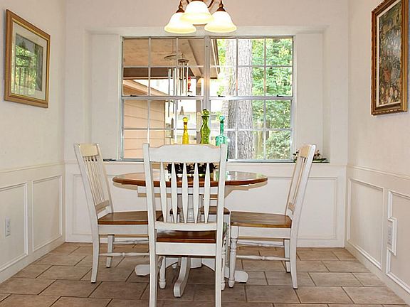 Over-sized breakfast room has beautiful custom molding and a large picture window overlooking the ba