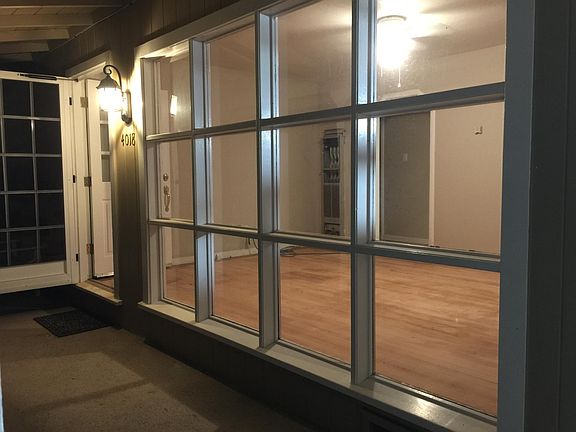 Night shot of really cool front window right after all the 1955 solid wood floors in the house got refinished! The porch has a tan epoxy coating with metal flakes