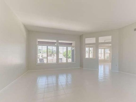 Formal Living Room. Gleaming white floors and plantation shutters