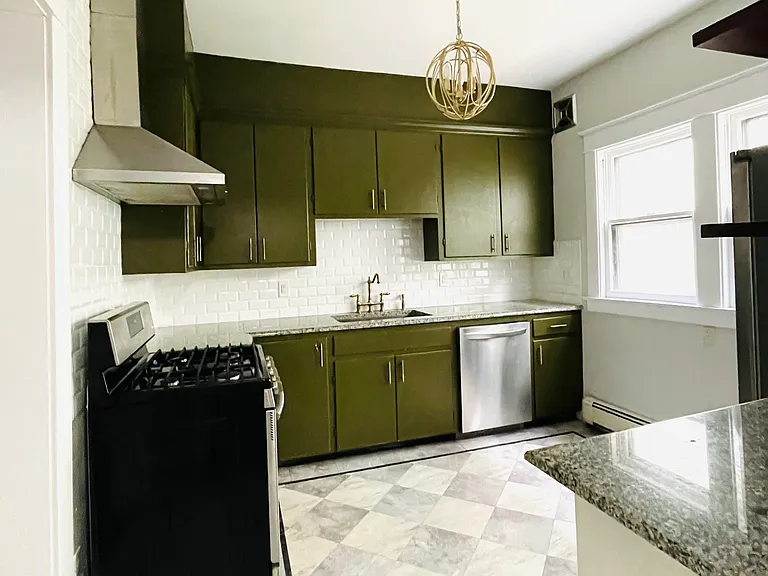 Kitchen with custom checker floor and custom painted green cabinets.
