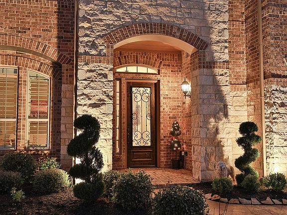 The beautiful exterior uplighting added to this home makes for stunning curb appeal at night.