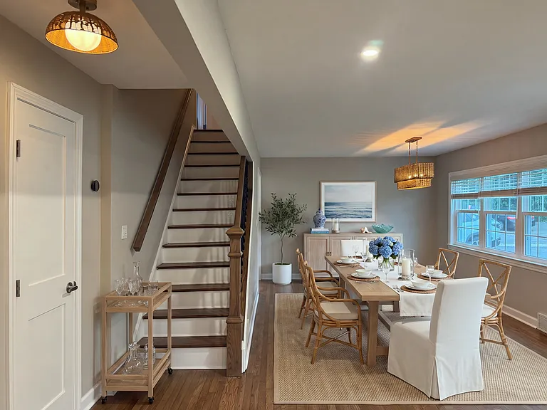 First floor includes mudroom, kitchen, open concept dining / family room, full bath, and guest bedroom with closet (virtually staged)