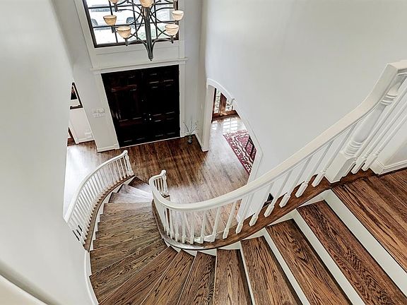 Double entry front doors open to a sweeping staircase and 2 story ceiling with beautiful chandelier.