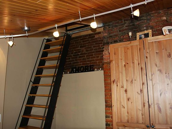 Custom wood/wrought iron sliding stair to private roofdeck.