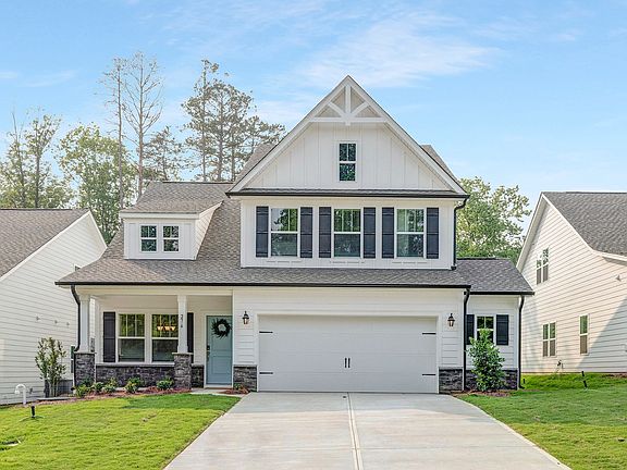 A large white house with a gray roof and black shutters
