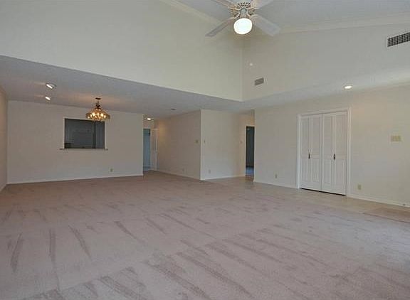 This photos shows the space of the living and the formal dining areas.  A pass through opening from the kitchen is part of the back wall.