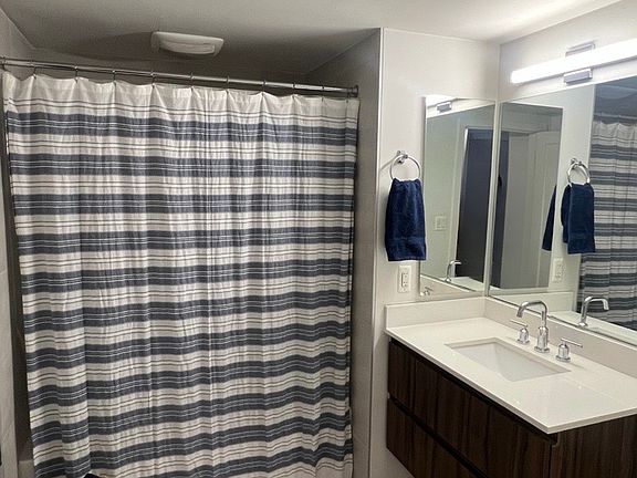 Spacious bathroom with vanity, shower/tub.