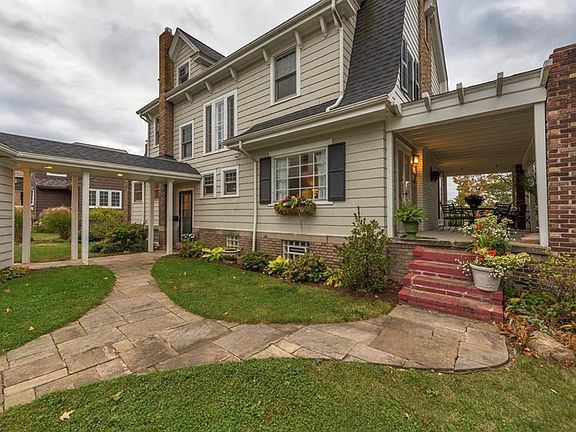 Sandstone paths lead from the driveway to the fantastic side porch.  Owners also designed a covered walkway from the garage to the back door.