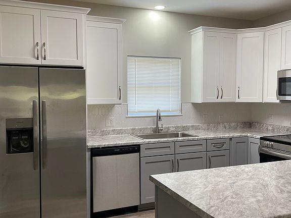 Kitchen with lots of cabinets, dishwasher, refrigerator, smooth top stove and built in microwave.