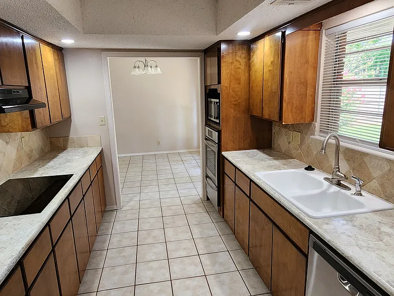 HUGE GALLEY STYLE KITCHEN OPENS TO PATIO EATING AREA ON ONE END AND THE LAUNDRY ROOM ON THE OTHER.