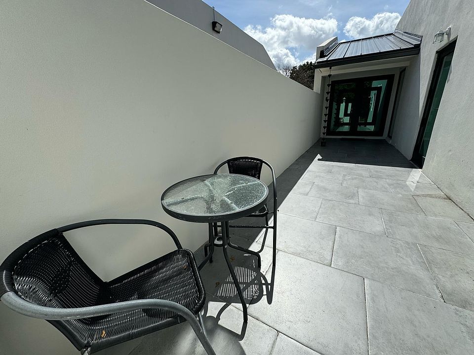 outside with a table and two chairs, main entrance