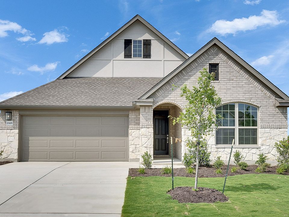 Elegant brick facade with arched entry and pristine landscaping in Mahogany at Carillon. Luxurious s