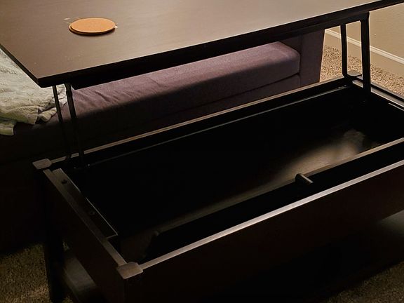 Coffee table is convertible to small table with space for magazine storage.