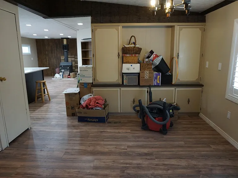 Dining area with coat closet and kitchen and second family room in background. Please excuse the items.