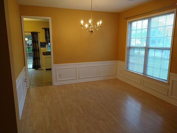 From Foyer, view of Empty Dining Room with passageway to Kitchen