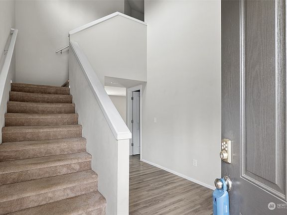 Entry with soaring ceiling and engineered hardwood floors that flow throughout the main living areas.>