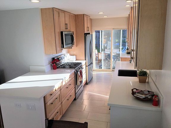 Galley kitchen leading from dining area to backyard