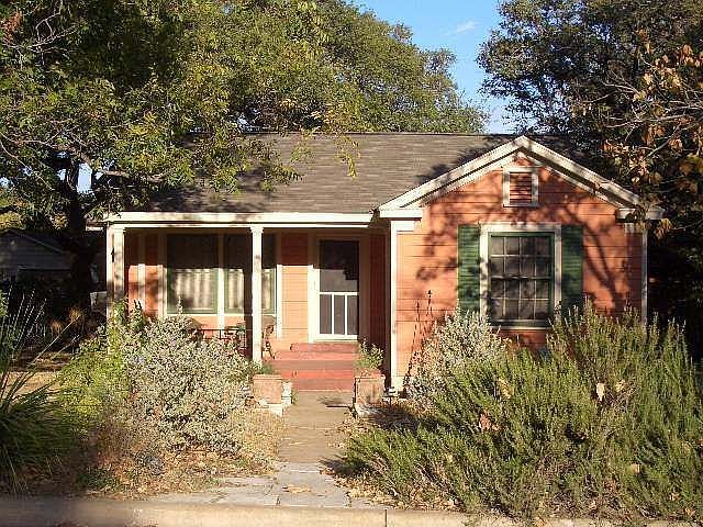 Front of home with covered porch, recent exterior paint & xeriscaped yard