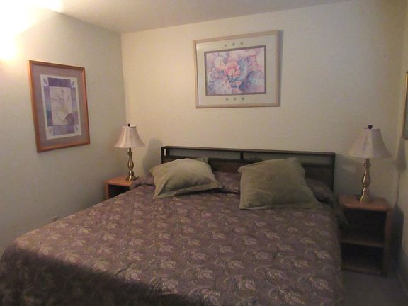 Matching bronze lamps add balance to the king bed.