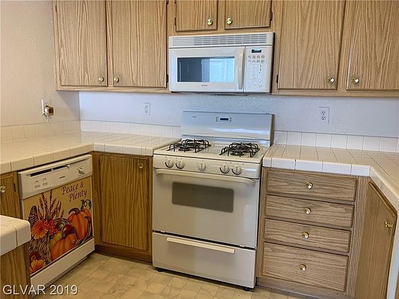 Kitchen with tile countertops. All appliances are included