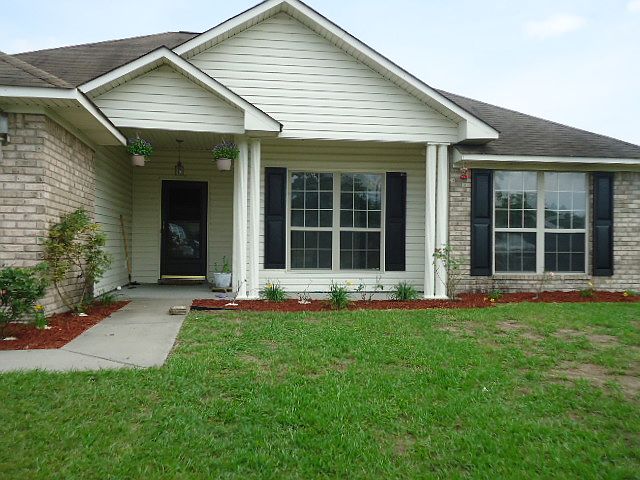 Front entry includes new mulch, existing plants and grass ya