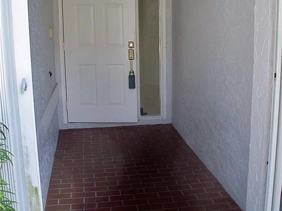 Covered entry porch with storm shutters and tiled