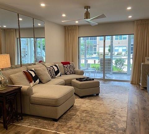 Open concept kitchen/dining/living room space opens to lanai w/ views of the pool.