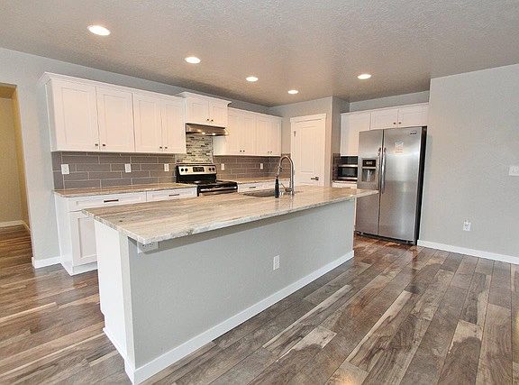 Granite counter tops with seating at island. Refrigerator, dishwasher and range included. Mudroom to the left.