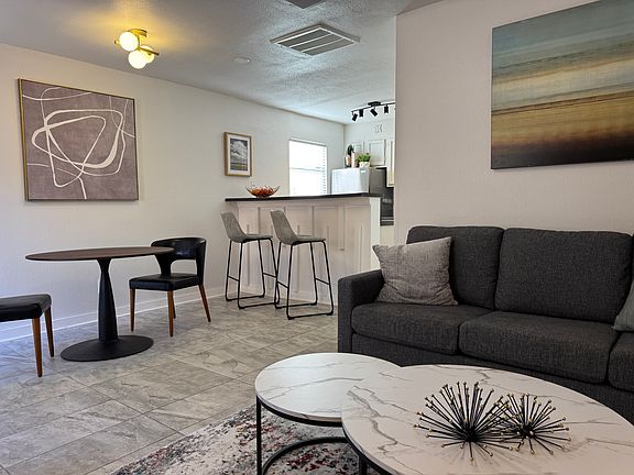 Living room open to the dining niche and bartop facing the kitchen.