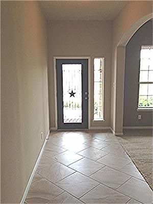 View of your entry with gorgeous front door, with tile entry, beautiful arch leading to your formal dining with carpet..