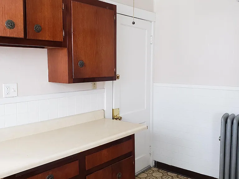 View of kitchen overhead cabinets and counter with below storage /drawers for additional storage, with view of back door for exit
