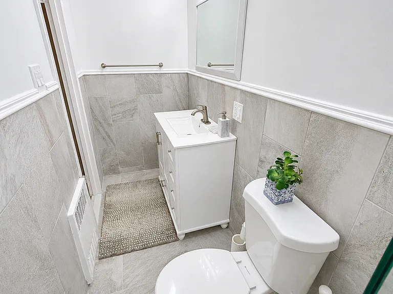 Clean, modern bathroom featuring stylish tilework, a glass-enclosed shower, and contemporary fixtures.