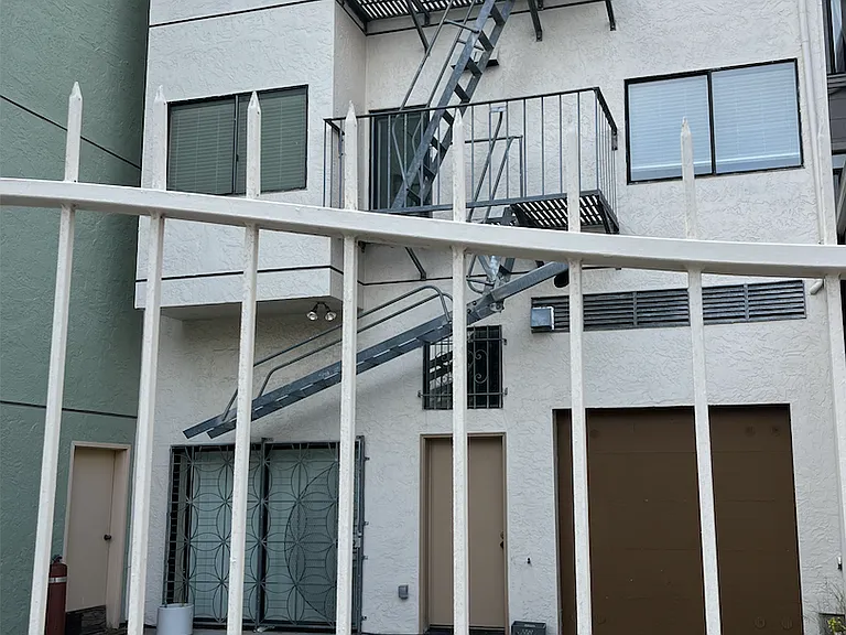 One car parking space behind building.