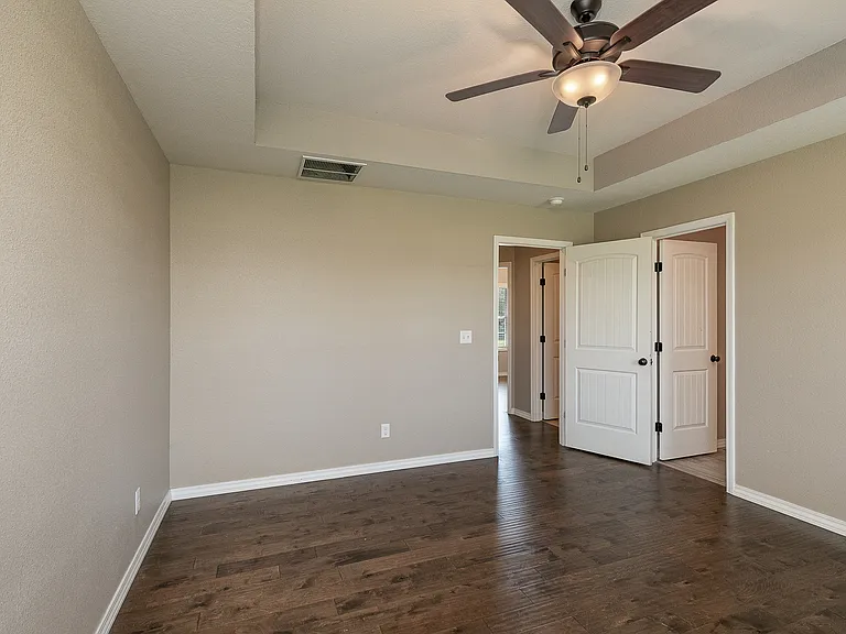 Bedroom with tray ceiling and ceiling fan