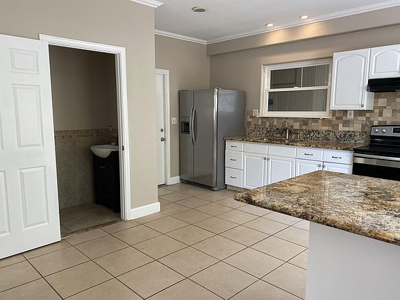 Half bathroom next to kitchen and door leading to enclosed garage.
