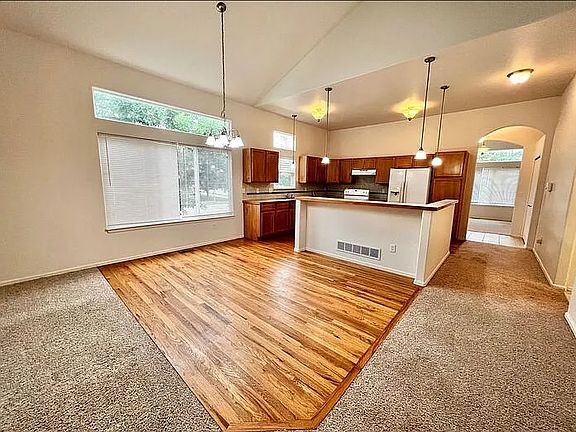 View of dining area, bar, and kitchen from the living room.
