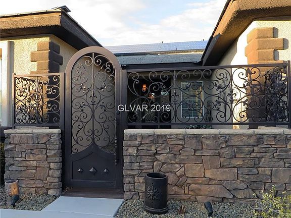 Granite rock trim and elegant custom iron gate and fencing.