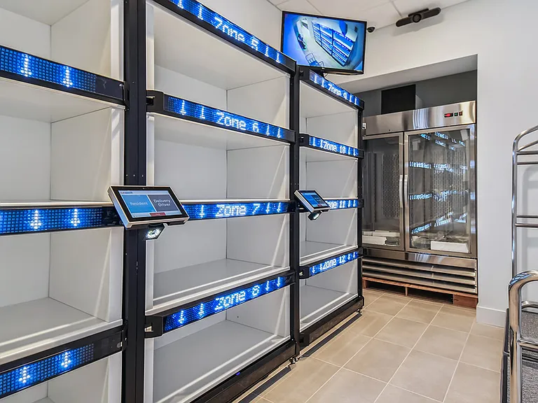 Griffis West Palm apartments package room with parcel delivery shelves.