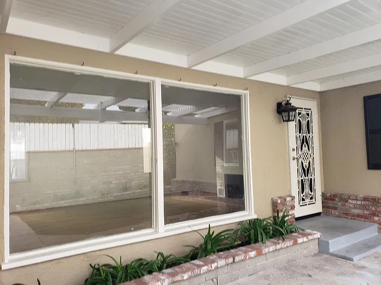 Living entry covered with vinyl patio cover. Patio area great room for BBQ in private gated yard and flower beds