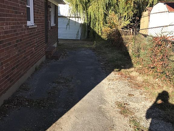 Left side of the house with additional side door to outside. Driveway and garage in the background
