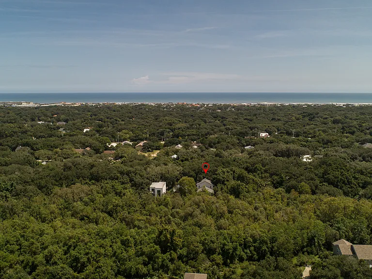 The best of both worlds! This stunning aerial view highlights how Coastal Soul Beach House sits nestled in a private, serene tree canopy while remaining just minutes from the sparkling ocean coastline
