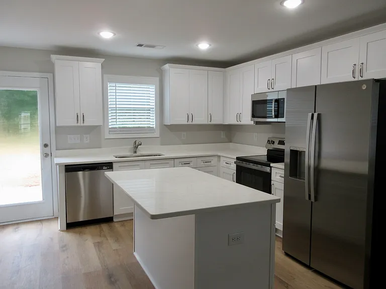 Kitchen w/many soft close cabinets, island, stainless steel fridge & gorgeous veined quartz countertops