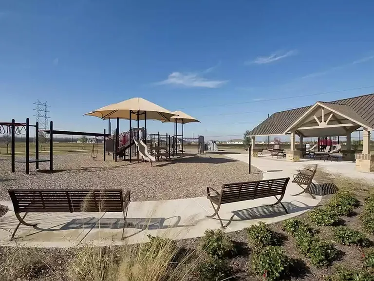 Community play ground and covered tables with benches on the right.