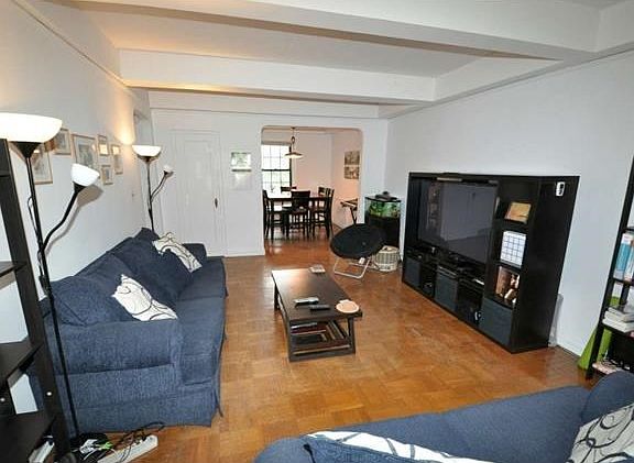 The living room looks out at the manicured courtyard and has an arched opening to the dining room. T