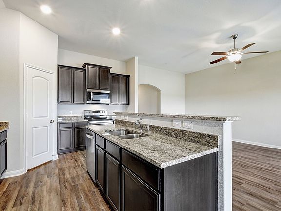 The kitchen features granite countertops and stunning wood cabinetry