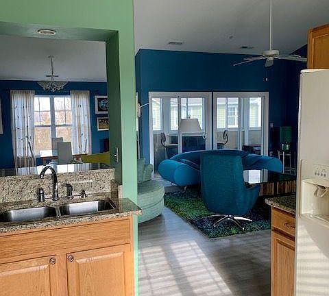 View from kitchen through living area and out to the lanai. Lanai has a bar with two chairs and two lounge chairs (not seen). Also, a window bird feeder for your enjoyment! Bird seed provided.