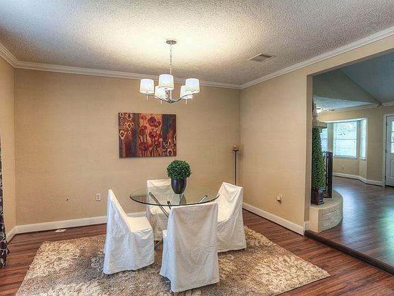 The dining room features a beautiful light fixture and hardwood flooring!