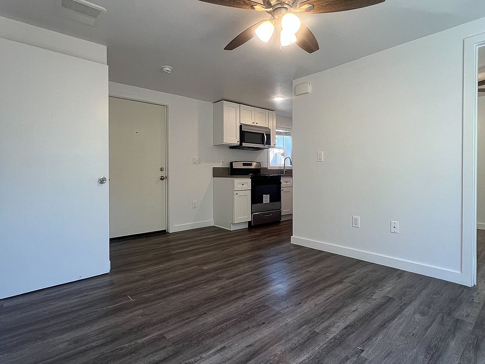 View of the living room while facing the front door. The kitchen is in the background.