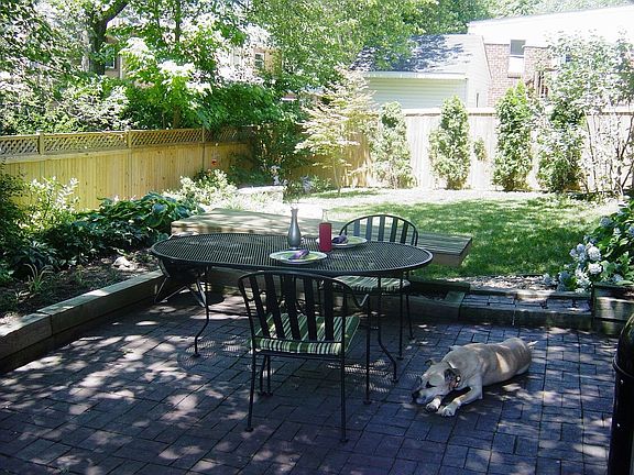Cozy brick patio under mature shade tree