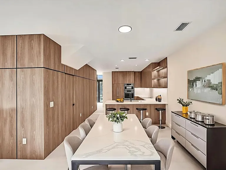 Luxury kitchen and dining room area with Bosch appliances, wood finish, LED lights. Ideal for entertaining or a private at home relaxation while enjoying your open space and pool view.